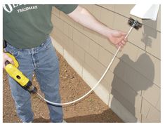 a man using a power drill to fix a wall