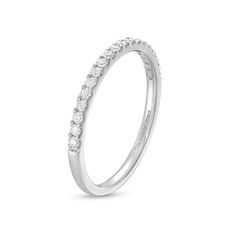 a white gold wedding band with round brilliant cut diamonds on the top and bottom edge