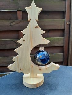 a wooden christmas tree with a blue ornament