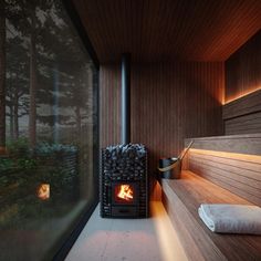 a wood burning stove sitting in the corner of a room next to a wooden wall