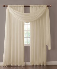 an open window with sheer curtains hanging on the side and a wooden rod in front