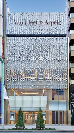 the entrance to an office building that is made out of metal mesh and glass panels