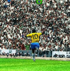 a soccer player is kicking the ball in front of a large crowd at a stadium