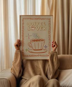 a person sitting on a couch holding up a sign with coffee lover written on it