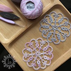 two crochet designs on a wooden tray next to yarn and scissors