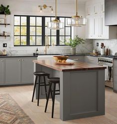 a kitchen with gray cabinets and wooden counter tops