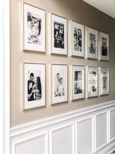 a wall with many pictures hanging on it's sides and white wainscoting