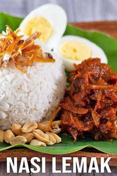 a plate with rice, meat and boiled eggs on it next to a banana leaf that says nasi lemak