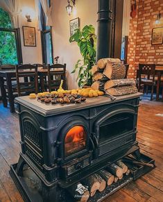 an old fashioned wood stove with logs stacked on top