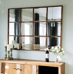 a wooden table with a mirror and vase on it