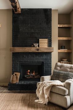 a living room with a couch, chair and fire place in front of a brick fireplace