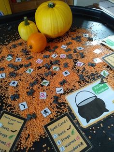 two pumpkins and some sort of card game sitting on a table with other cards