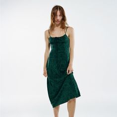 a woman in a green dress is standing