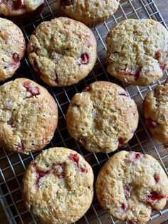 freshly baked muffins cooling on a wire rack with cranberry toppings