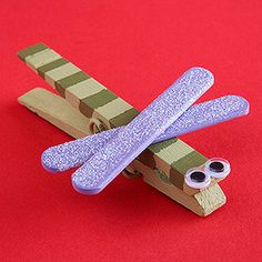 a paper dragonfly made out of popsicle sticks with text overlay reading magnetic dragonfly clips