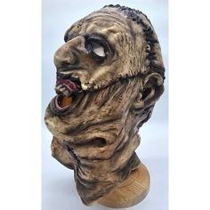 a creepy looking mask on top of a wooden stand