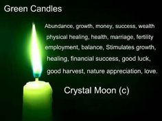 a green candle with the words crystal moon on it's side, in front of a black background