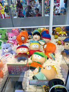 a display case filled with lots of stuffed animals in different colors and sizes sitting on top of cotton balls