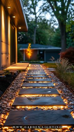 a walkway made out of stones with lights on the side and trees in the background