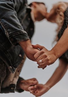 a man and woman holding hands while standing next to each other