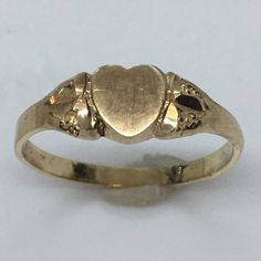 Antique Heart Shape 14K GOLD Signet RIng 1.0 Gram Size 5.25 Never Engraved This antique signet ring is a true beauty. Crafted from 14k yellow gold, it features a heart-shaped design that exudes elegance and sophistication. The ring is perfect for any occasion and is a great addition to any jewelry collection. With a weight of 1.0 gram and a size of 5.25, this ring is a perfect fit for anyone. It has never been engraved and does not feature any diamonds or gemstones. The vintage design adds to its charm and makes it a unique piece. Don't miss out on the opportunity to own this exquisite piece of fine jewelry. 6 mm wide on top Antique Yellow Gold Wedding Ring Stamped 14k, Antique Yellow Gold Heart Cut Jewelry, Classic Gold Signet Ring For Promise, Gold Engraved Ring Hallmarked 14k, Gold Classic Signet Ring For Promise, Gold Engraved Hallmarked 14k Ring, Gold Engraved 14k Ring Hallmarked, Antique Yellow Gold Engraved Hallmarked Ring, Gold Engraved Wedding Ring With Hallmarks