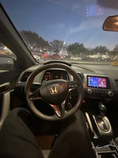 the interior of a car with dashboard, steering wheel and dash lights on at night