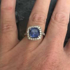 a woman's hand with a ring on it and a blue stone in the middle