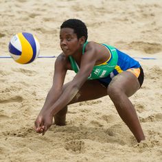 a woman is playing volleyball in the sand