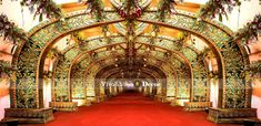 an ornate archway with red carpet leading to the top floor and bottom half is decorated with flowers