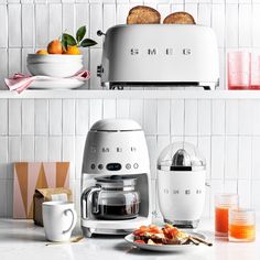 two toasters sitting on top of a counter next to plates and bowls filled with food