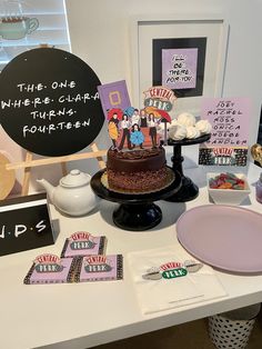 a table topped with a chocolate cake covered in frosting next to cards and other items