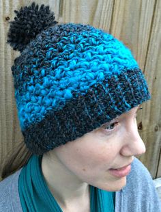 a woman wearing a blue and black knitted hat