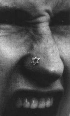 a black and white photo of a man's nose with a piercing on it