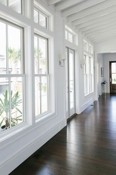 an empty hallway with wood floors and white walls