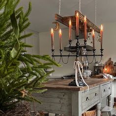 a chandelier with lit candles hanging from it's ceiling in a kitchen