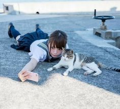 a person laying on the ground with a cat