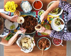 people eating food from bowls and plates on a table