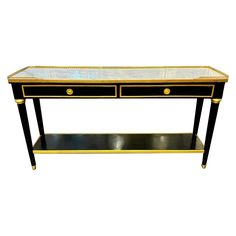 a black and gold console table with marble top