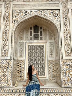 a woman standing in front of an ornate doorway