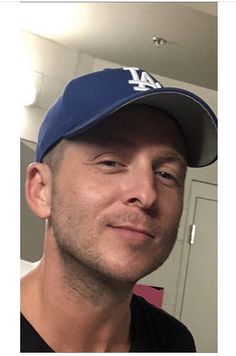 a man wearing a baseball cap and looking at the camera with a smile on his face