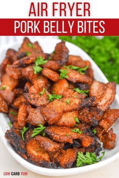 air fryer pork belly bites in a white bowl with parsley on the side