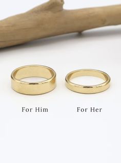 two gold wedding bands sitting next to each other