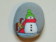 a painted rock with a snowman and dog on it