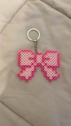 a pink and white pixel keychain with the word love spelled on it