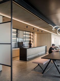 two people are sitting at a table in an office with black and white accents on the walls