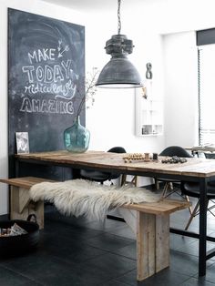 an instagramted photo of a dining room table and bench with chalkboard on the wall