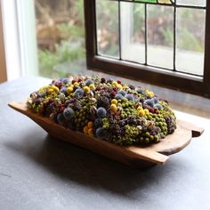 a wooden platter filled with lots of different types of food on top of a table