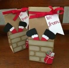 two brown paper bags with santa hats and stockings on them