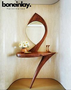 a wooden shelf with a mirror and vase on it in front of a white wall