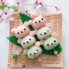 four small stuffed animals sitting on top of a bamboo tray next to flowers and beads